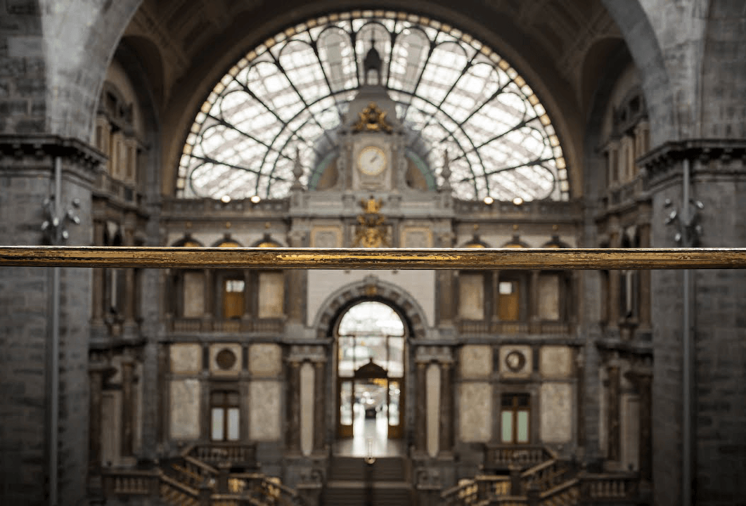 Interior view of a train station featuring a large half-circle window that allows natural light to illuminate the space.
